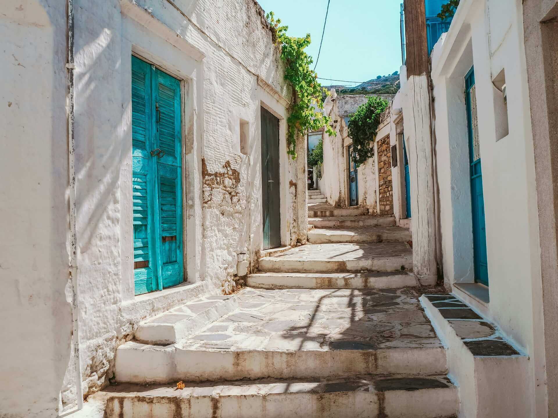 Traditional Naxos village alley with white houses and turquoise doors